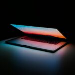 黒い空間にノートパソコンが置いてある画像