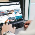 ノートパソコンでサイトをみている男性の画像