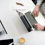 ノートパソコンをオフィスでいじっている画像