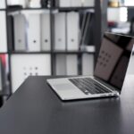 黒い机の上にノートパソコンが置いてある画像