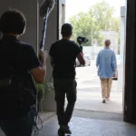 暗い室内から明るい屋外へ移動する被写体を追う撮影チーム