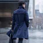 冬の街でロングコートを着用する様子