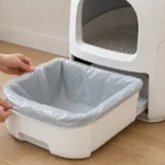 猫用自動トイレのごみ受けへ交換用袋を取り付ける様子