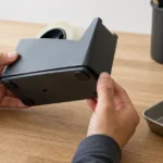 卓上テープカッターの底部を外して部品を確認する場面