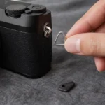 カメラのストラップ取付部へ三角リングを装着する場面