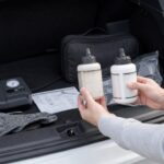 車載パンク修理キットの古い補修液と交換用補修液を確認している様子