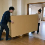 大型の荷物を廊下の曲がり角へ通して搬入経路を確認する場面