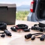 車載冷蔵庫のそばに複数の電源コードやアダプターを並べたイメージ