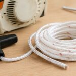 チェーンソー用スターターロープと交換用ハンドルを作業台に置いた様子