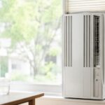 窓に設置された白い窓用エアコンがある明るい室内