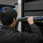AV over IP機器をつなぐネットワークラックの配線を確認する技術者