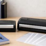 オフィスの机に大小2台の熱製本機と書類を並べたイメージ