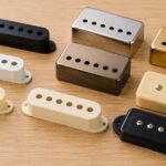 木目の上に複数種類のギターピックアップカバーを並べたイメージ