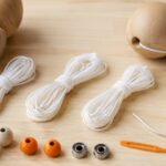 木製けん玉と交換用の白い糸、ビーズ、ベアリングを並べた様子