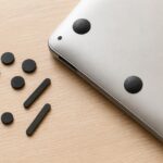 ノートパソコンの底面と複数の交換用ゴム足を並べたイメージ