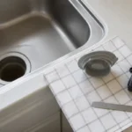 キッチンシンクから外した排水口部品を測る準備