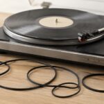 レコードプレーヤーの前に複数の交換用ゴムベルトを並べたイメージ