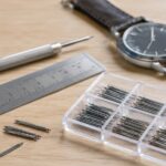 腕時計とバネ棒、定規、交換工具を並べたイメージ
