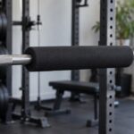 スクワットラックのバーベル中央に黒いパッドを装着した様子