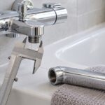 浴室水栓の接続部をノギスで測り、交換用スパウトを選ぶイメージ