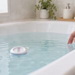 浴槽に浮かぶ湯温計でお湯の温度を確かめる様子