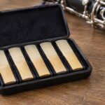 クラリネットのそばに複数のリードを収めたケースが置かれている様子