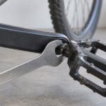 自転車のペダル軸に薄型レンチを掛けた様子