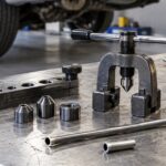 自動車整備工場の作業台にブレーキパイプとフレア加工工具を並べた様子