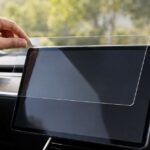 車内の大型タッチ画面に透明な保護フィルムを重ねる様子