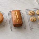 丸いケーキとパウンドケーキ、クッキーを異なる大きさの冷却網に載せた様子