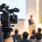 業務用ビデオカメラで講演会を撮影している様子