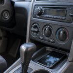 車内のAUX端子につながれた小型受信機とスマートフォン