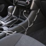 車内のセンターコンソール周辺でケーブルをクリップに固定している様子