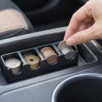 車内のトレイに置いたコインホルダーから硬貨を取り出す様子