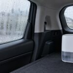 雨で結露した車内の窓と荷室に置かれた小型除湿機