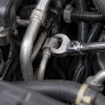 車の狭い配管ナットにクローフットレンチを掛けた様子