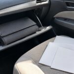 車のグローブボックスに無地の書類ケースを収納している様子