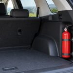 車の荷室側面に赤い消火器を固定している様子