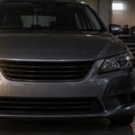 片側のヘッドライトが消えた車を整備士が点検している様子