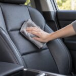 車の本革シートをクロスで拭いている様子