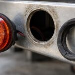 車体パネルから外れた丸型LEDマーカー灯と劣化したゴムグロメット