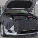 車の左右フェンダーと前面を整備用カバーで保護している様子