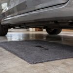 車の下に敷いた吸収マットが油滴を受け止めているガレージの様子