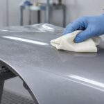 車の塗装面に残った細かな粉じんをクロスで取り除く様子