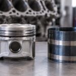 車用ピストンとリングを締めるバンド工具を作業台に並べた様子