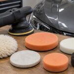 車のそばにポリッシャーと複数種類の交換用バフを並べた写真