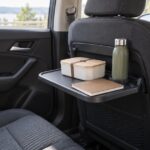 後部座席の折りたたみテーブルに弁当箱と水筒、ノートを置いた車内の様子