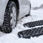 雪にはまった車のタイヤと2枚の脱出用ラダーボード