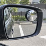 駐車場の白線を映す車のサイドミラーと丸型補助鏡