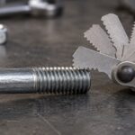 車整備用ボルトとリーフ式ねじピッチゲージを並べた様子